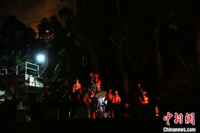 31日凌晨，消防救援人员在液化气站现场，远处的大火清晰可见。　袁吕 摄